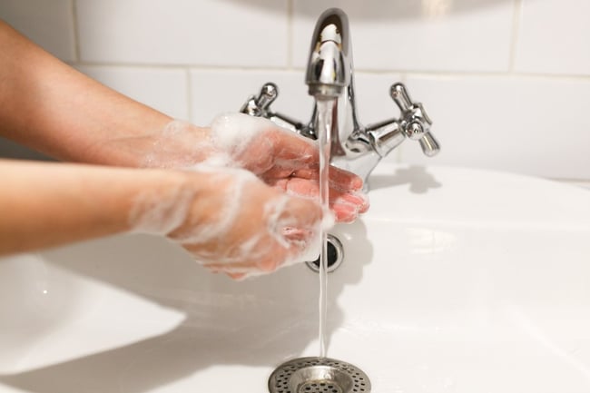 01 Una persona lavandose las manos en el grifo bimando mezclador de un lavabo
