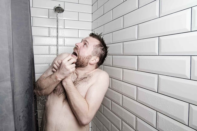 02 Un hombre sorprendido por el agua fria en la ducha porque el calentador dejo de funcionar
