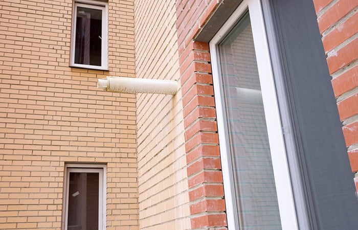 03 Chimenea de una caldera de gas saliendo en posicion horizontal a traves de la fachada de un edificio