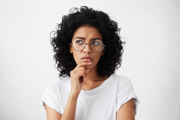 03 Mujer joven con gafas en actitud pensativa y dudosa