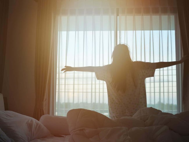 03 Mujer recien levantada estirandose frente a la ventana