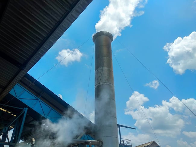 03 Plano de una chimenea industrial emitiendo humo blanco al cielo