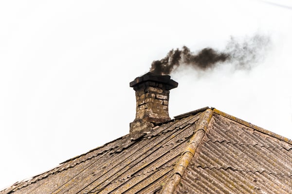 03 Una chimenea de tejado emitiendo humo negro