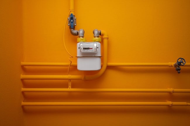 04 Una instalacion de gas con tuberias y un gasometro todo pintado de amarillo intenso