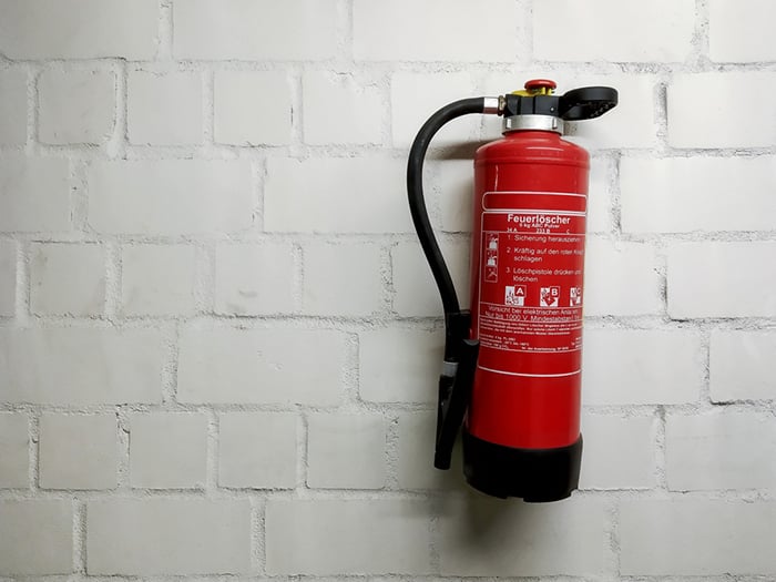 05 Un extintor de fuegos colgado de una pared