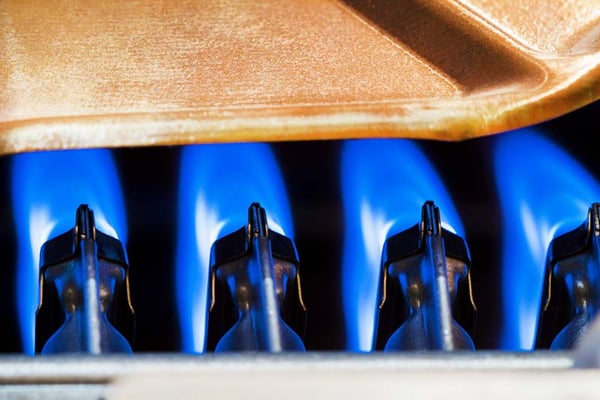 08 Llama azul intensa en el quemador de un moderno calentador de agua a gas
