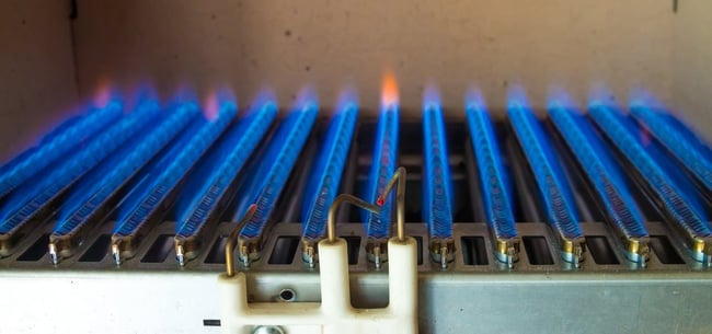 11 Inyectores con llama azul en un quemador de gas de caldera o calentador